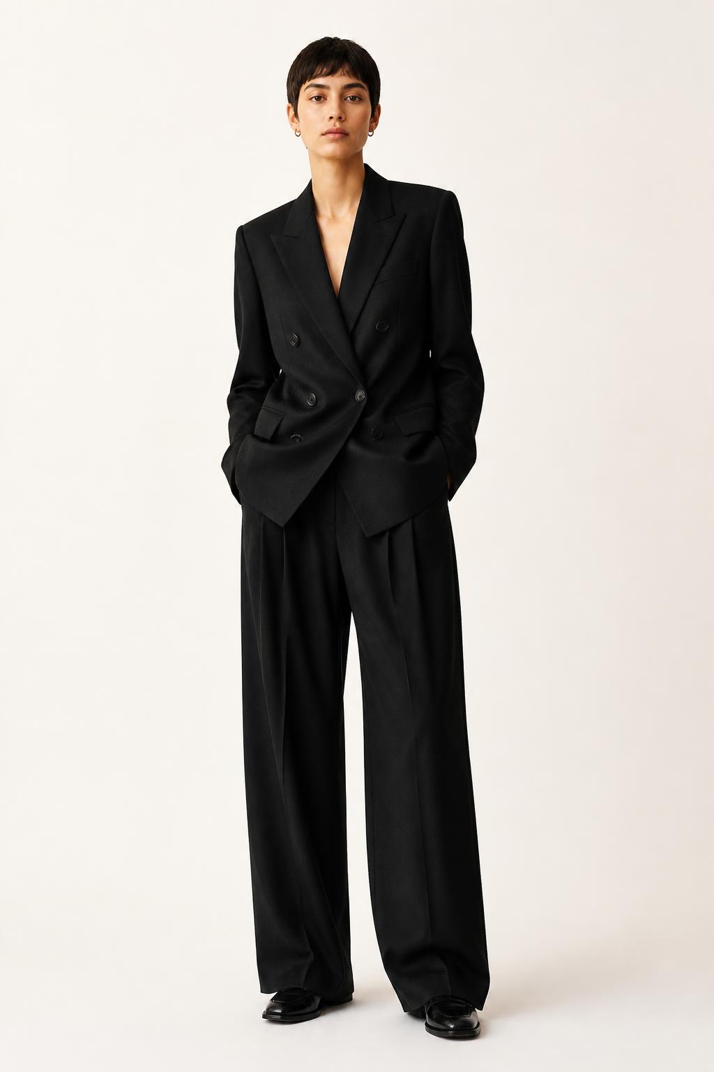 Front full-body view of the UNSTRCT W02 double breasted suit in black