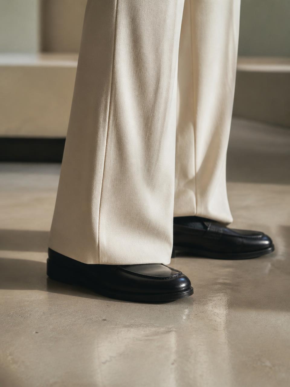 Black leather shoe under the break of a wide UNSTRCT trouser